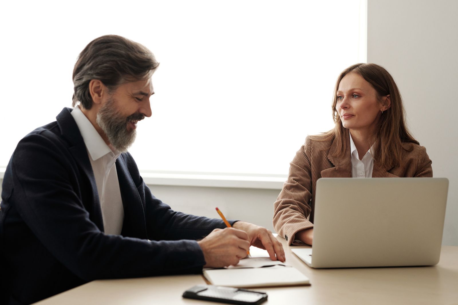 Small business owner delegating IT management, laptop open.