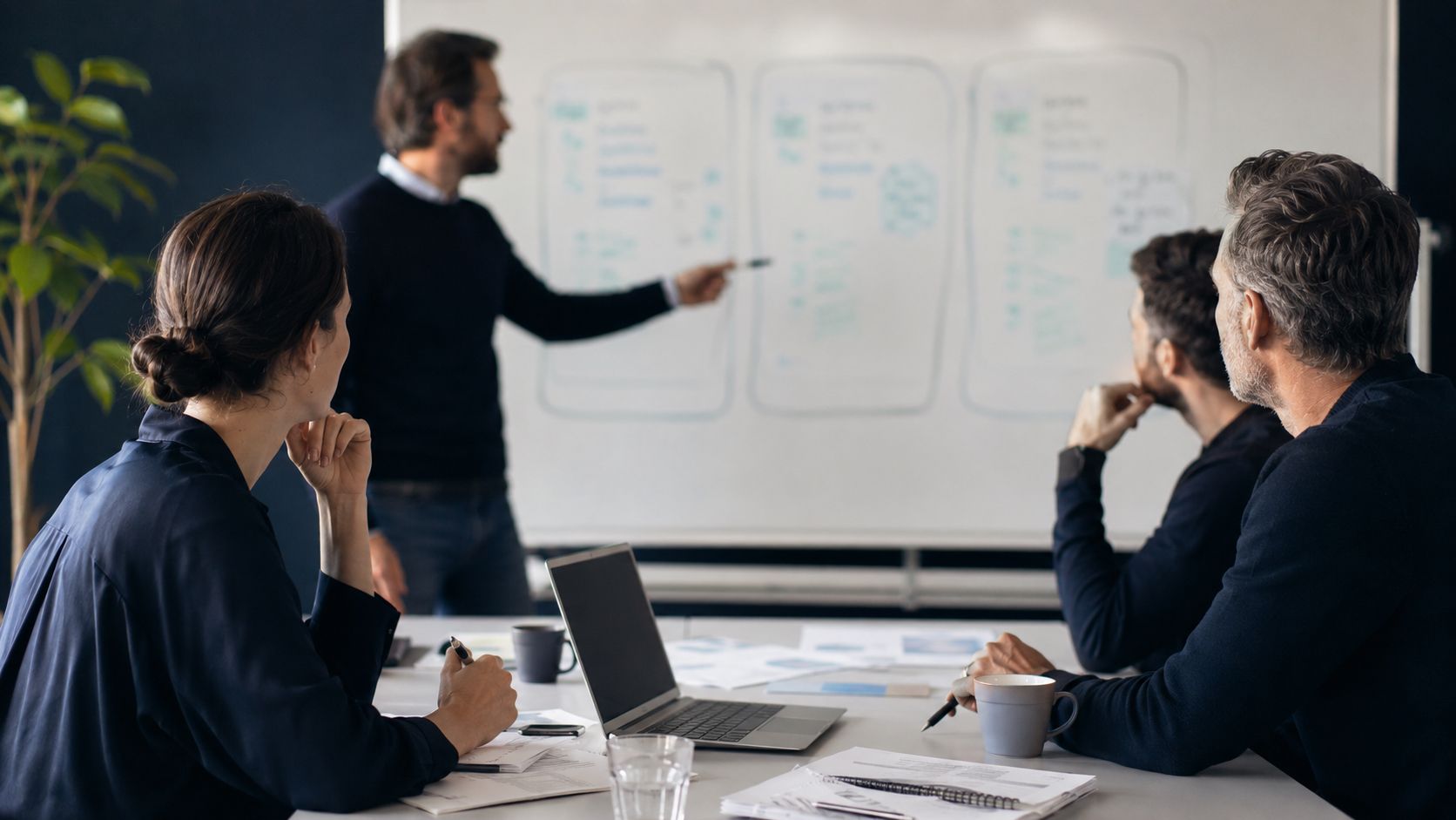 Deux professionnels collaborant sur des ordinateurs portables dans un bureau moderne.
