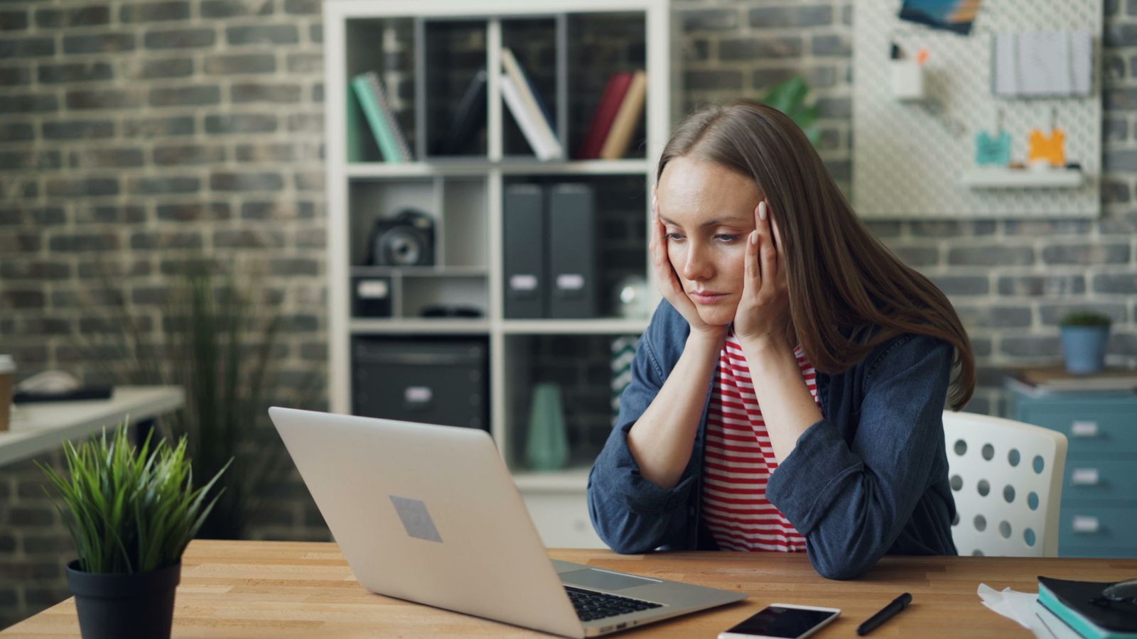 Worried small business owner in front of a locked computer screen.