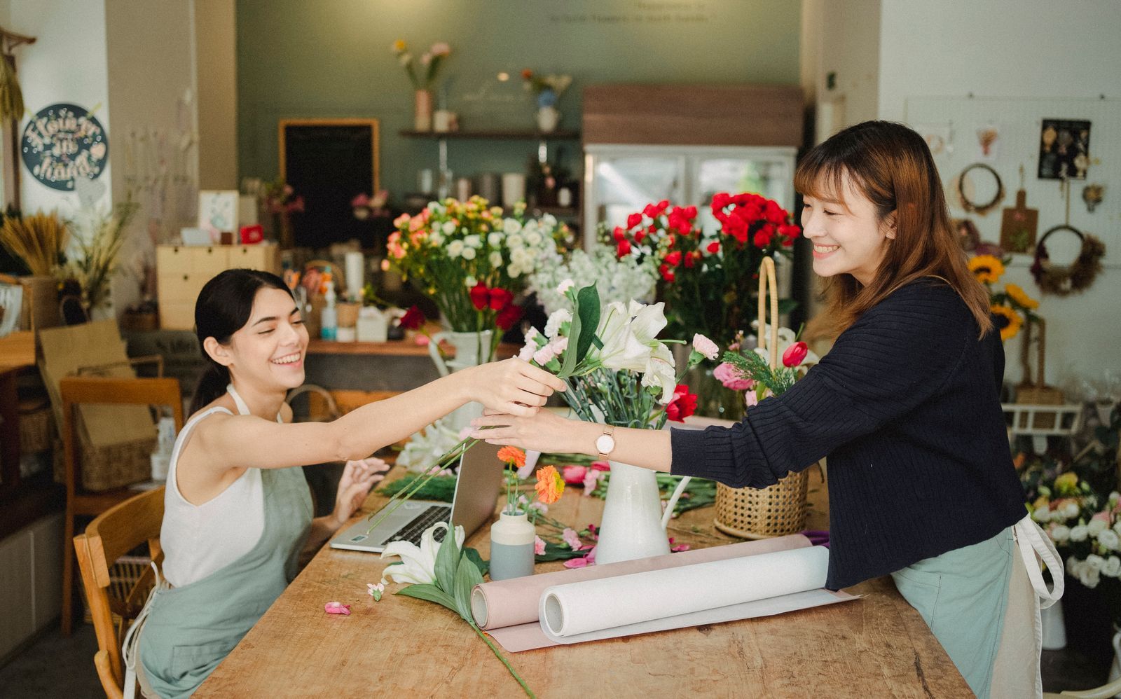 Dirigeante de petite entreprise travaillant sur un ordinateur portable dans son commerce.